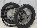 two dirt bikes that are sitting on a tile floor