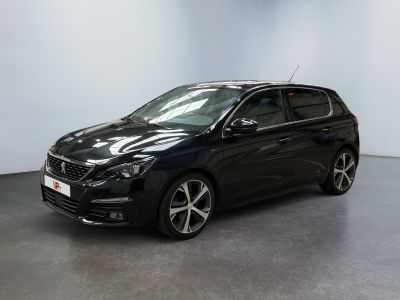 une voiture noire garée dans une pièce aux murs blancs