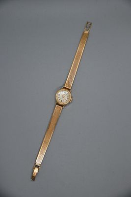 une montre-bracelet en or avec un cadran blanc sur un fond gris