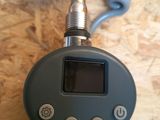 a digital thermometer sitting on a table with a cord