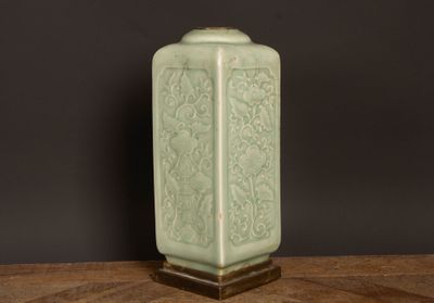 un vase vert posé sur une table en bois