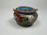 a red and blue vase with flowers on it