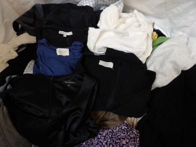 une pile de vêtements posée sur un lit