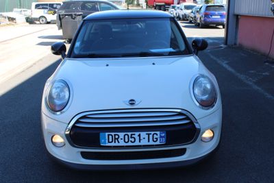 a small white car parked on the side of the road