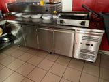 une cuisine équipée d'appareils électroménagers en inox et aux murs rouges