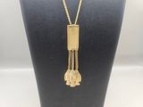 a gold plated necklace with a long chain and a tassel