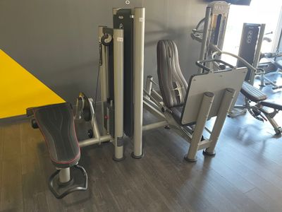 une salle de sport avec une table jaune et deux appareils de musculation