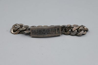 un gros plan d'un bracelet en métal entouré d'une chaîne