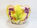 a yellow and purple vase sitting on a white surface