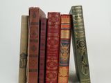 plusieurs vieux livres sont empilés sur une surface blanche