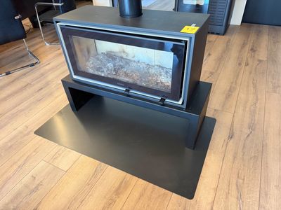 un poêle noir posé sur un plancher en bois