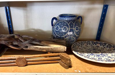 un vase bleu et blanc posé sur une étagère, à côté d'une assiette bleue et blanche et d'une assiette bleue et blanche