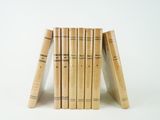 several books stacked on top of each other on a white surface