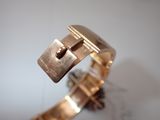 a close up of a gold bracelet with a lock on it