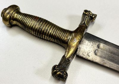 gros plan d'une épée sur une surface blanche