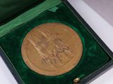 a gold medal sitting in a green box on a table