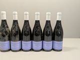 six bouteilles de vin sont alignées sur une table