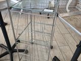 une table en verre sur laquelle sont disposées trois chaises noires