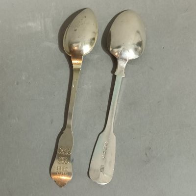 two spoons that are sitting next to each other on a table