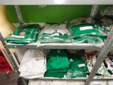 many bags of clothing on a shelf in a store