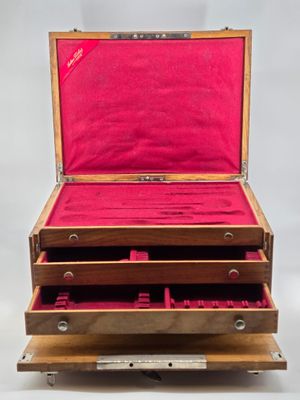 an open wooden box with three drawers on top of it