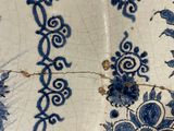 a close up of a blue and white tile with flowers