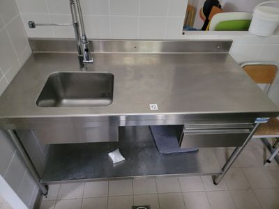 un évier en acier inoxydable et un plan de travail en acier inoxydable dans une cuisine