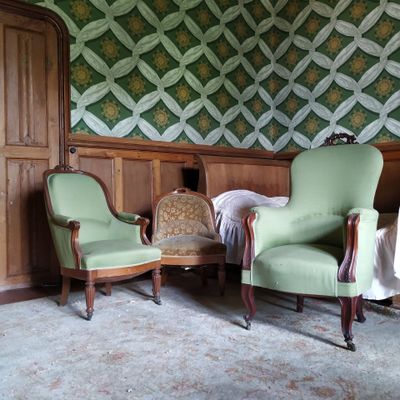 deux chaises vertes dans une pièce dont l'un des murs est tapissé