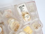 many different types of jewelry in a plastic container