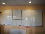 a whiteboard on the wall in a room with a radiator