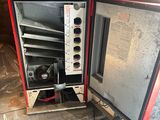 a small red and black oven sitting inside of a building