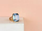 a close up of a ring with a blue topaz stone