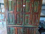 une très vieille armoire en bois au milieu d'une pièce