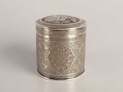 an antique silver metal container with a decorative design on the lid