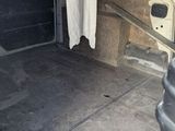 the back of a van with the door open and a trash can in the back of the van