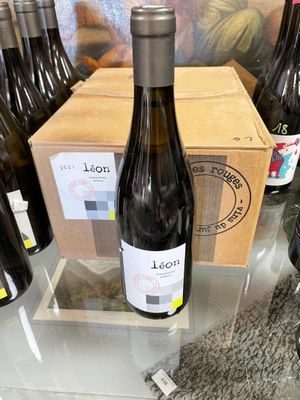 several bottles of wine sit on a table in front of a box of wine