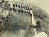une vieille photo en noir et blanc d'une femme debout devant un avion