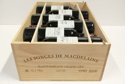 bouteilles de vin dans un coffret en bois sur une surface blanche