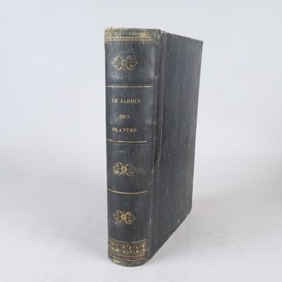 un vieux livre à la couverture noire posé sur une surface blanche