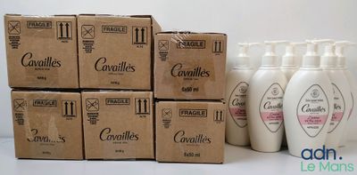 plusieurs flacons de lotion posés sur une table, à côté d'une boîte en carton