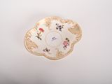 a plate with a flower design on it on a white surface
