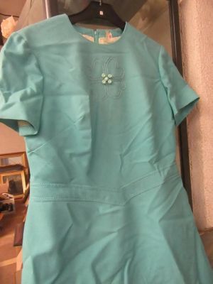 une robe bleue suspendue à un cintre dans une pièce