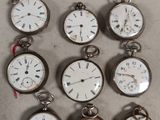 many different types of pocket watches sitting on a table