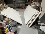a pile of junk in a garage with a refrigerator and other items