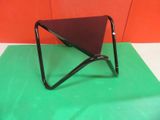 a small triangular table with a black top on a green mat