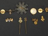 several different types of brooches and pins on a black surface