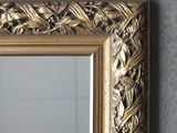 a gold framed mirror hanging on a wall next to a mirror