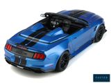 the blue car is parked on a white surface with the top down