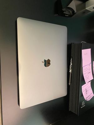 a white apple laptop sitting on a desk with sticky notes on it