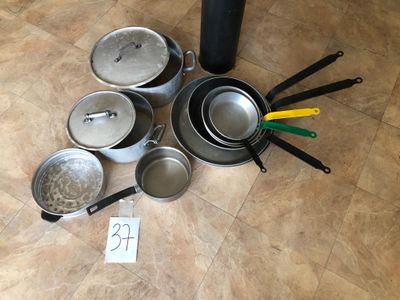 many pots and pans sitting on the floor next to each other